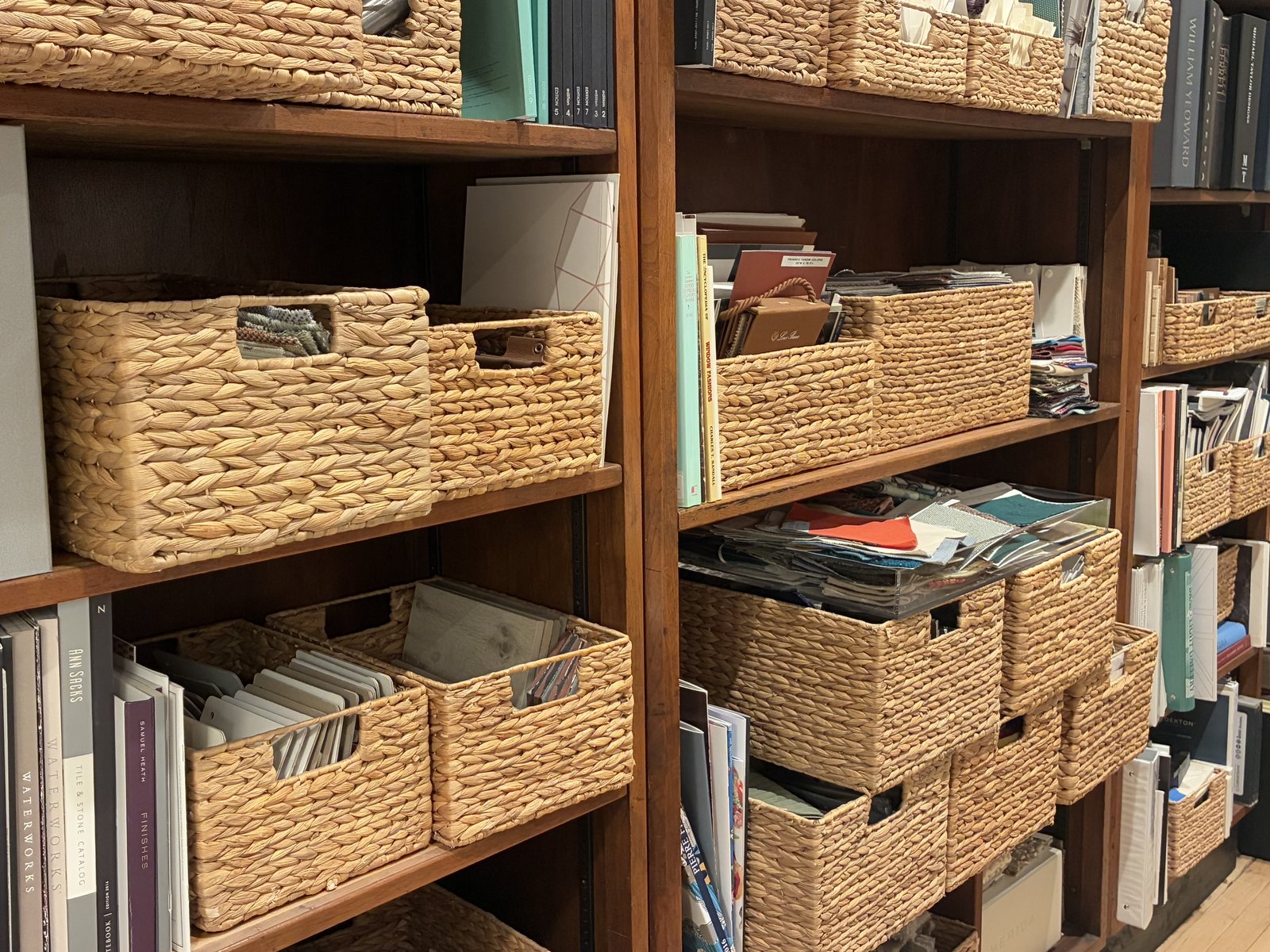 Studio library shelves of sample books and woven baskets